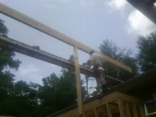 Carpenter setting a ridge beam over a new addition frame — Ice Dam Removal by Roofing Brothers in Lake Saint Louis