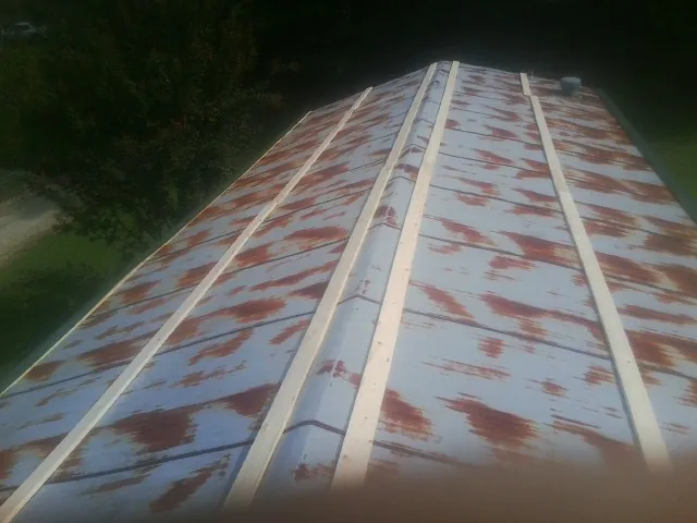 Rusted metal roof panels with new wood purlins before replacement — Storm Damage Roof Repair in Lake Saint Louis by Roofing Brothers