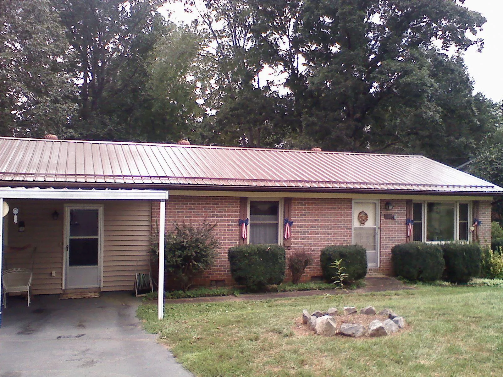 Bronze metal roof and carport on a brick ranch home — Roof Repair work by our crew in Lake Saint Louis