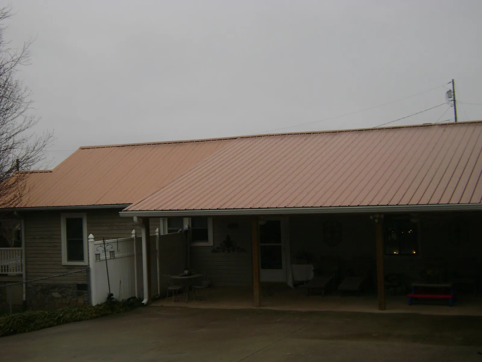 Copper toned metal roof over a wide covered patio in Lake Saint Louis
